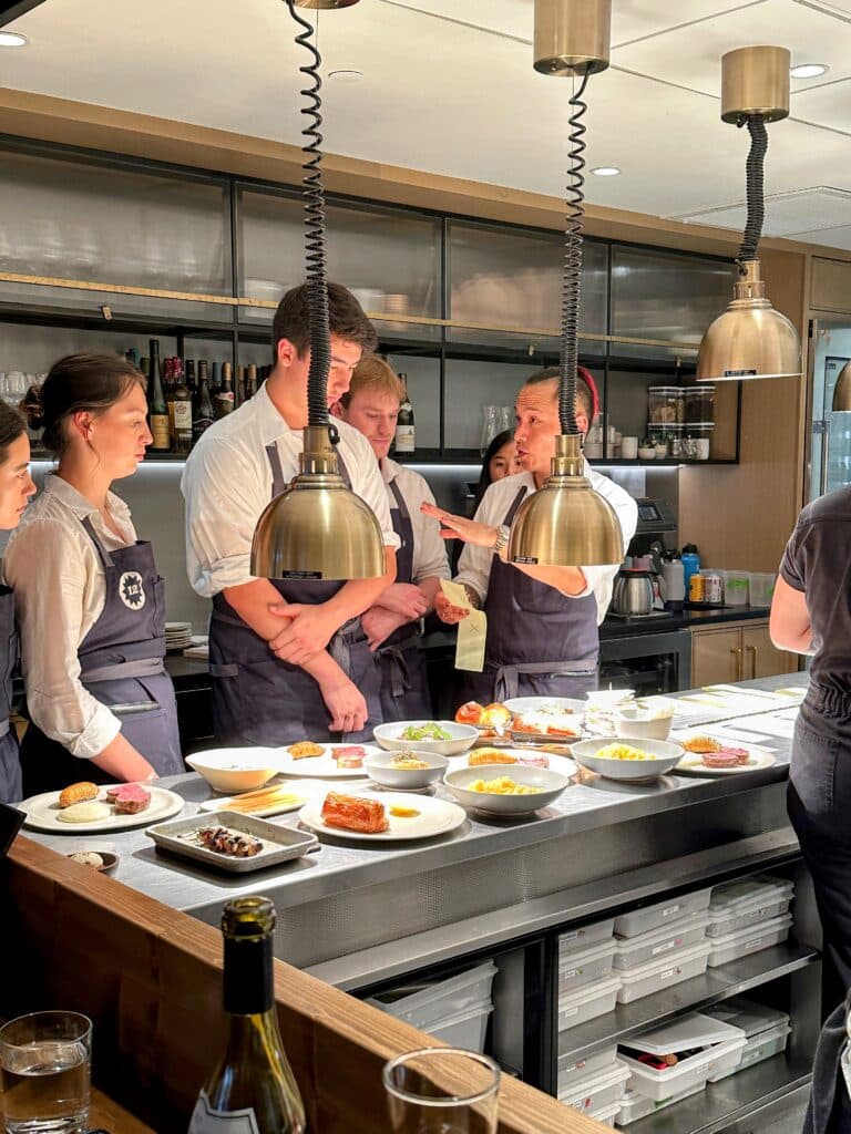 People standing at the chef's counter at Twelve