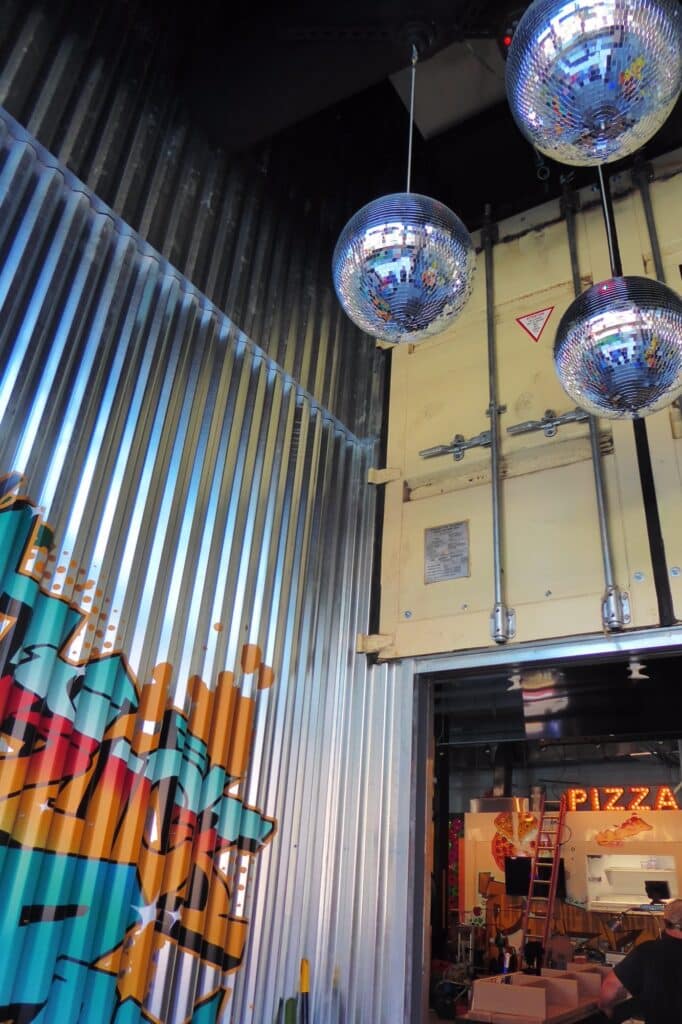 7th Street Truck Park entryway with graffiti graphic and disco balls hanging from the ceiling