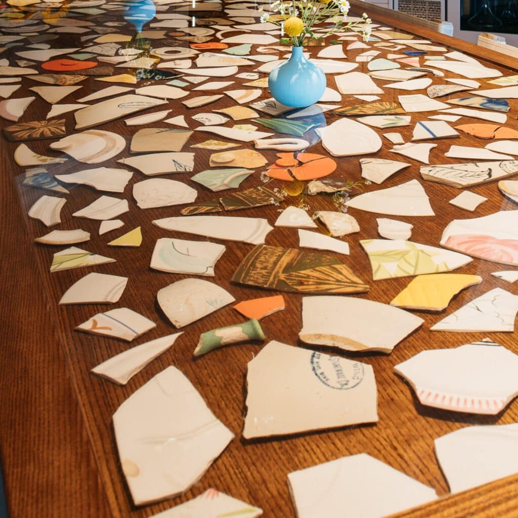 Redwing stoneware and pottery pieces in epoxy bar top table